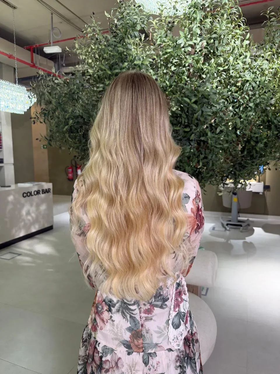 Long wavy blonde hair with highlights, viewed from the back.
